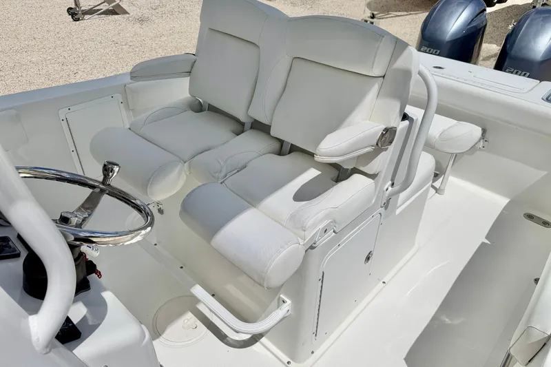 Slide: The Image of 2018 Sea Hunt Gamefish 27 boat interior with dual white captain's chairs and steering wheel. - 13