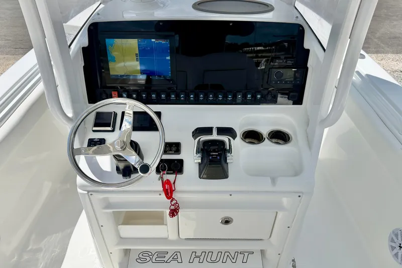 Slide: The Image of 2018 Sea Hunt Gamefish 27 boat dashboard with steering wheel and navigation display. - 16
