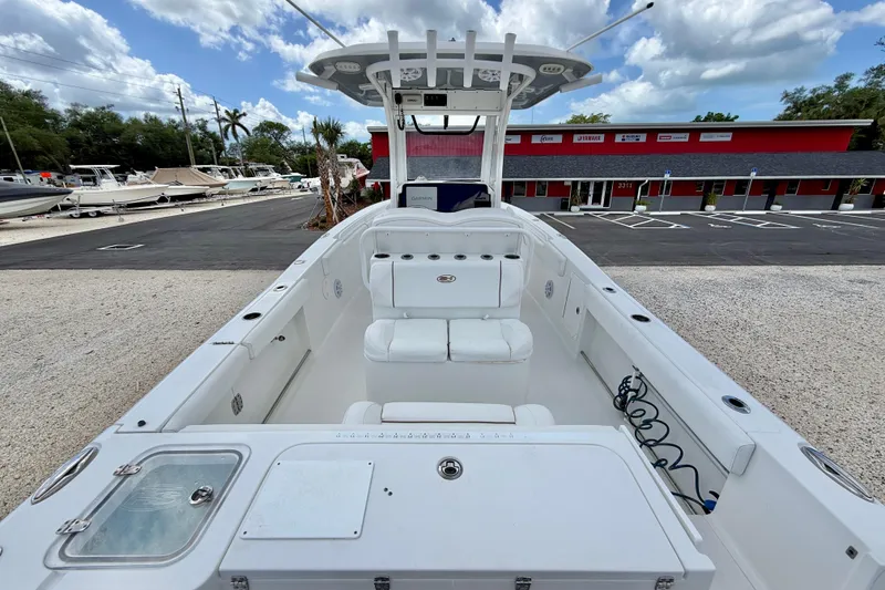 Slide: The Image of 2018 Sea Hunt Gamefish 27 boat interior with seating and storage, parked outdoors. - 28