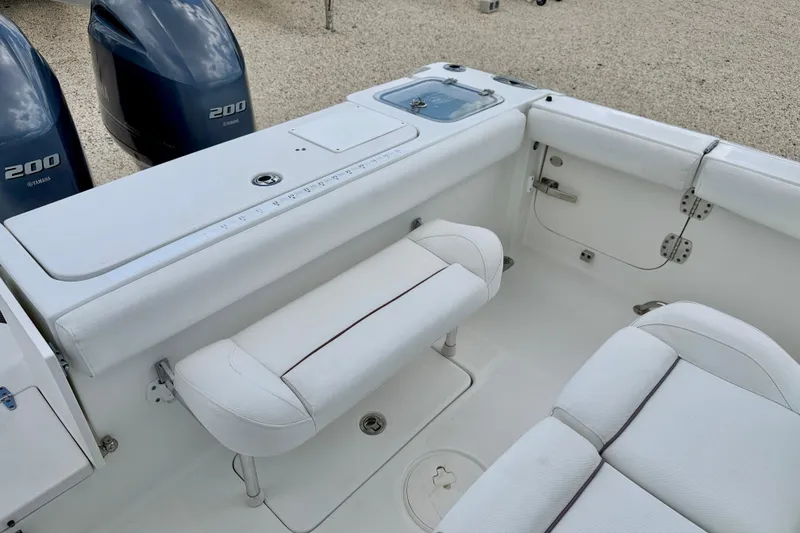 Slide: The Image of 2018 Sea Hunt Gamefish 27 boat interior with Yamaha 200 engines, featuring white seating and storage. - 32