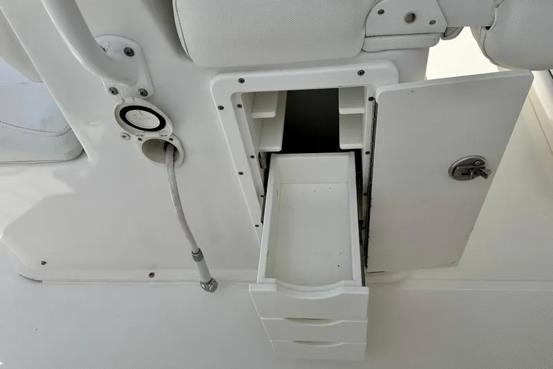 Slide: The Image of 2018 Sea Hunt Gamefish 27 boat storage compartment with open drawer and hose connection. - 35
