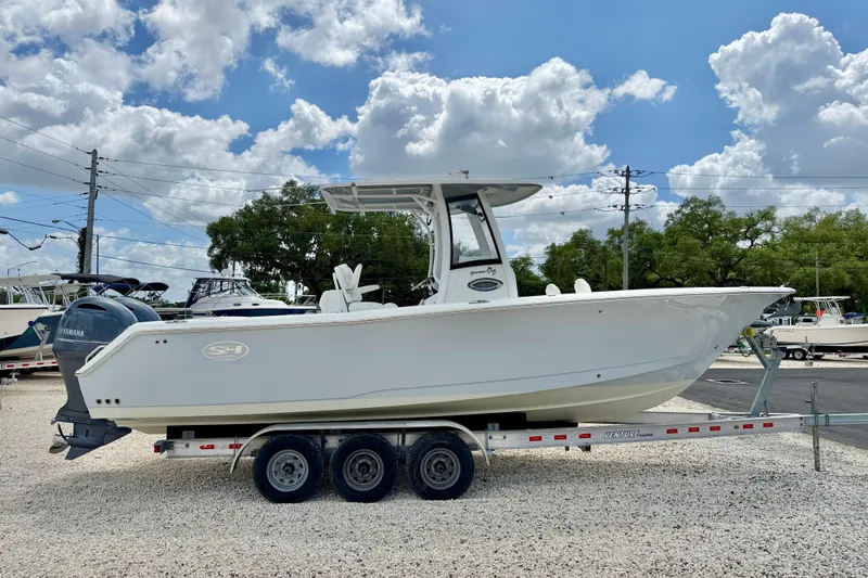 Slide: The Image of 2018 Sea Hunt Gamefish 27 boat on trailer under blue sky. - 4