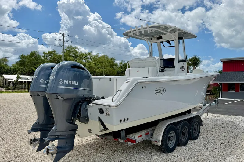 Slide: The Image of 2018 Sea Hunt Gamefish 27 boat with dual Yamaha engines on a trailer. - 5