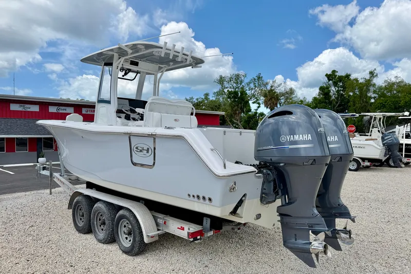Slide: The Image of 2018 Sea Hunt Gamefish 27 boat with dual Yamaha engines on a trailer. - 7