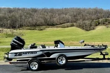 The Image of 2011 Nitro Z-6 boat on trailer, parked with scenic green hills in the background. - 1