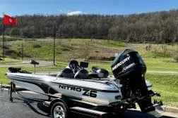 Slide: The Image of 2011 Nitro Z-6 boat with Mercury engine on trailer, parked in scenic outdoor setting. - 9