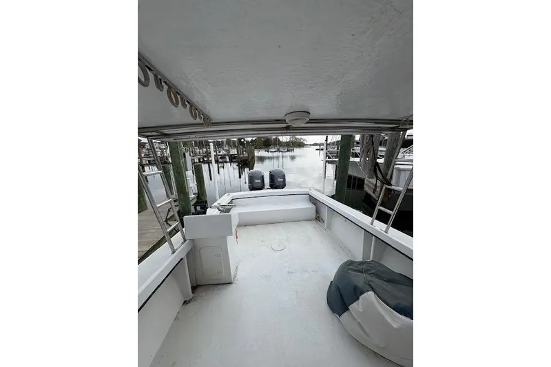 Slide: The Image of 1989 C-Hawk 29 Sport Cabin boat interior with dual outboard motors at dock. - 10