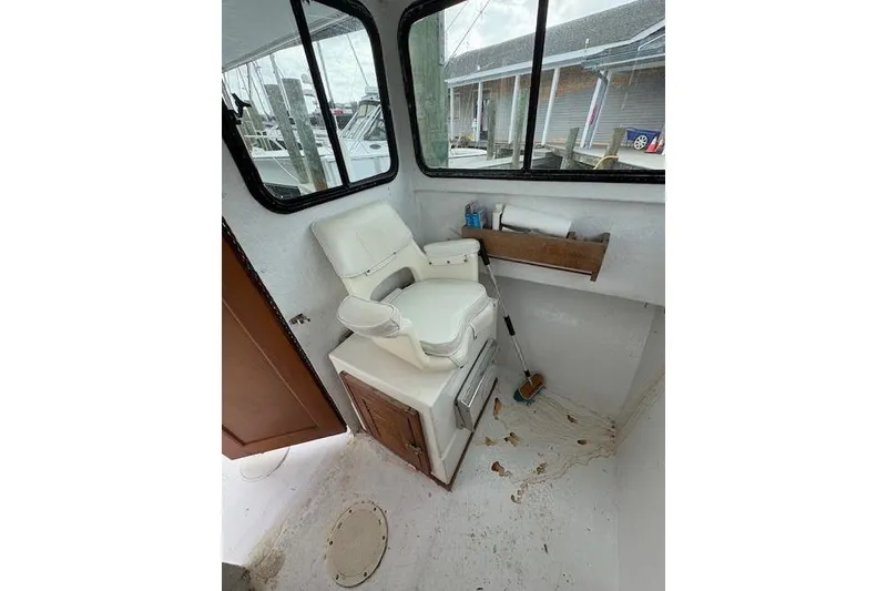Slide: The Image of 1989 C-Hawk 29 Sport Cabin interior with white captain's chair and storage. - 12