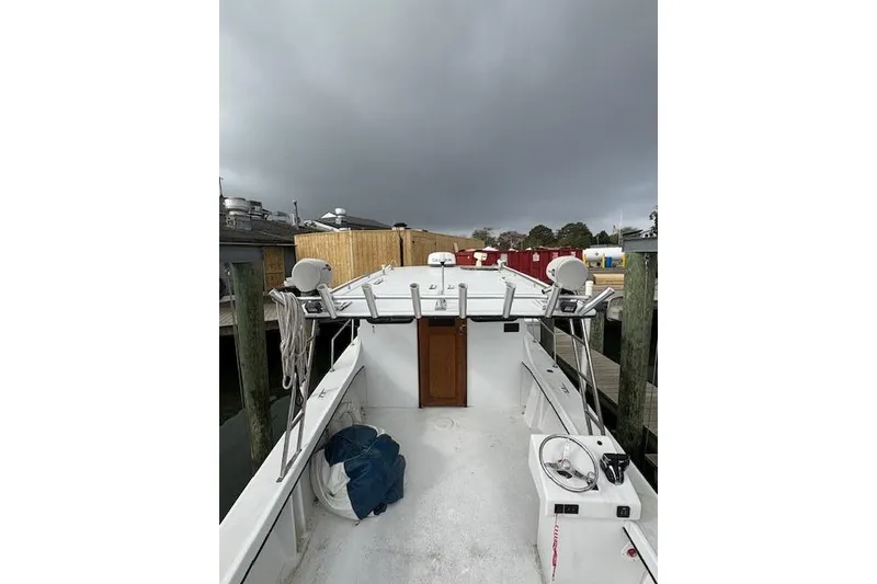 Slide: The Image of 1989 C-Hawk 29 Sport Cabin boat docked under cloudy skies. - 16