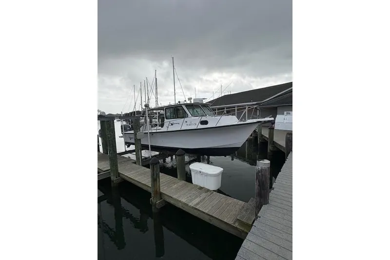 Slide: The Image of 1989 C-Hawk 29 Sport Cabin boat docked at marina under cloudy sky. - 19