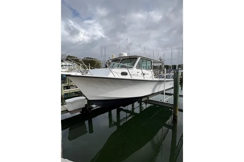 Slide: The Image of 1989 C-Hawk 29 Sport Cabin boat docked at marina under cloudy sky. - 4