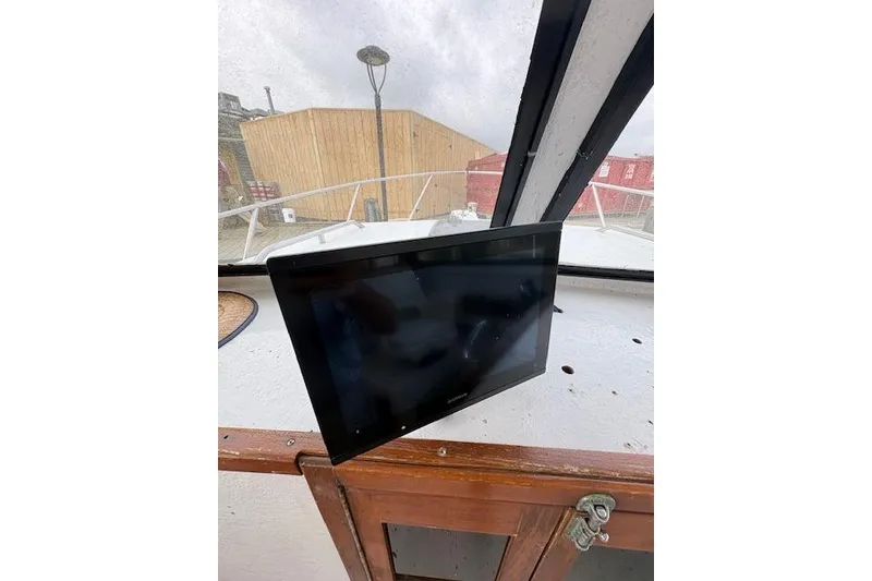 Slide: The Image of 1989 C-Hawk 29 Sport Cabin interior with mounted screen and wooden cabinet. - 9