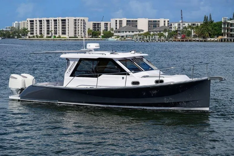 The Image of 2022 True North 34 boat cruising on a scenic waterfront with city skyline. - 0