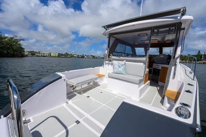 Slide: The Image of 2022 True North 34 boat with spacious deck and modern seating on a sunny day. - 15