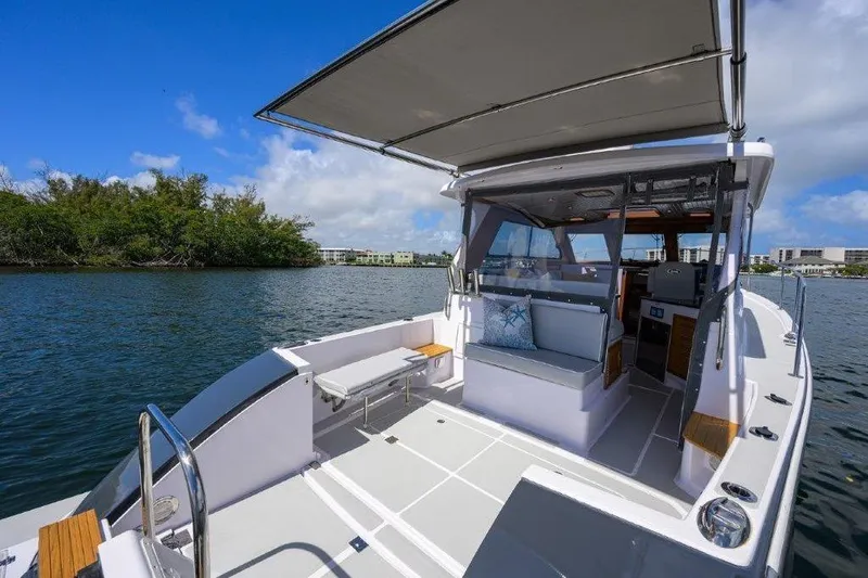 Slide: The Image of 2022 True North 34 boat with spacious deck and seating, cruising on a sunny day. - 22