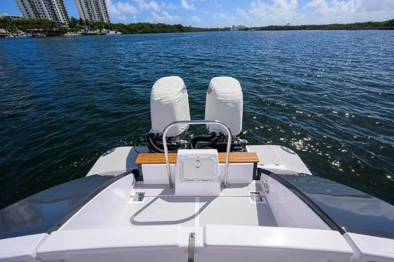 Slide: The Image of True North 34 boat, 2022 model, on calm water with cityscape background. - 34