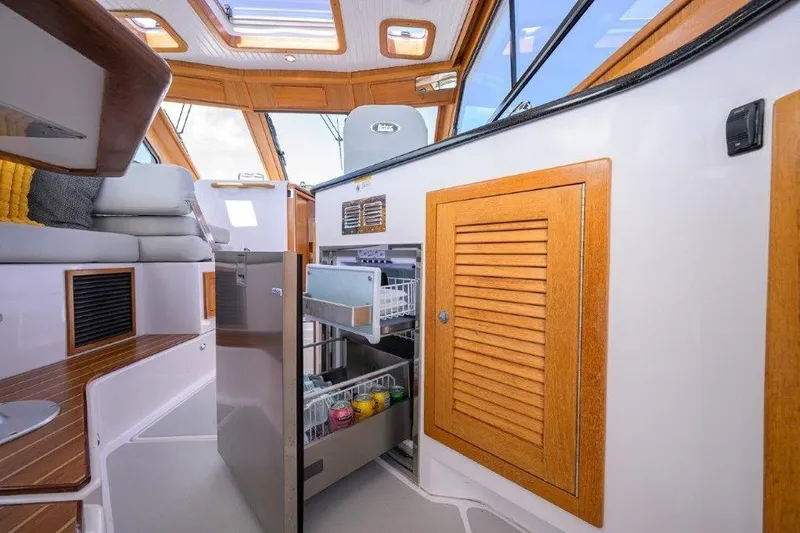 Slide: The Image of Interior of 2022 True North 34 yacht with open fridge and wooden cabinetry. - 56