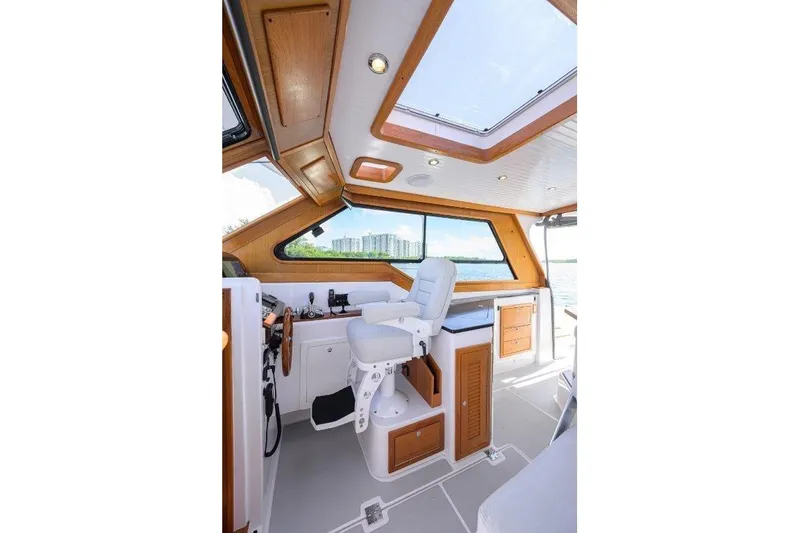 Slide: The Image of Interior of 2022 True North 34 boat with modern helm and wooden accents. - 66