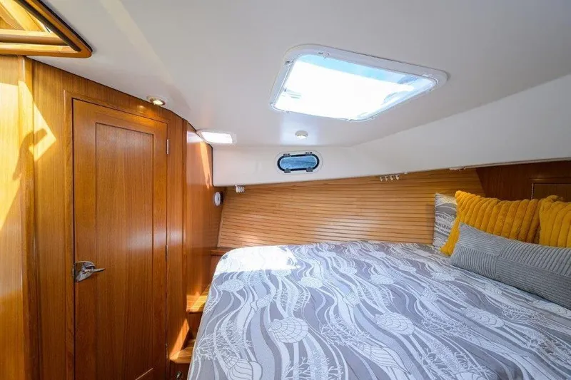 Slide: The Image of Cozy cabin interior of 2022 True North 34 yacht with wooden accents and skylight. - 73