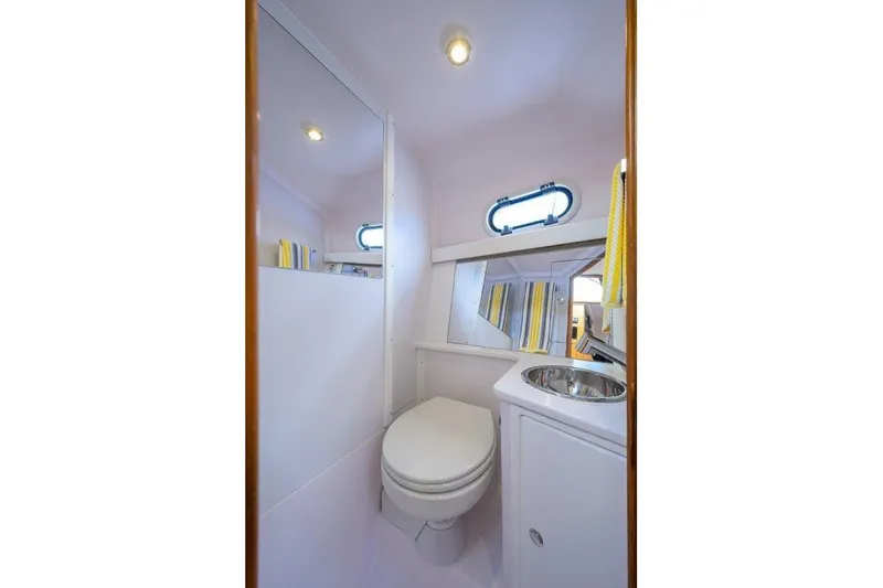 Slide: The Image of Compact bathroom in 2022 True North 34 boat with toilet, sink, and window. - 77