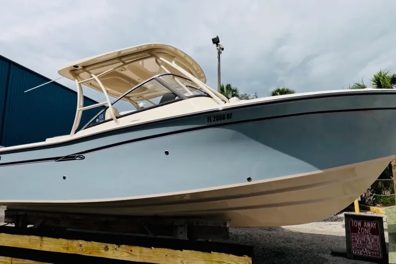 Slide: The Image of 2016 Grady-White Freedom 275 boat on display, light blue hull, parked outdoors. - 113