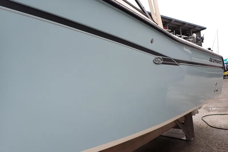 Slide: The Image of 2016 Grady-White Freedom 275 boat side view, docked on a stand. - 117