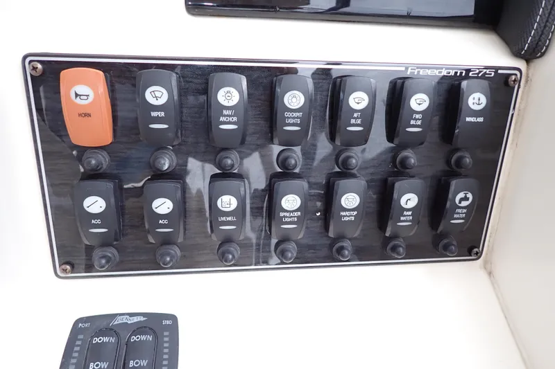 Slide: The Image of Control panel of a 2016 Grady-White Freedom 275 boat with labeled switches. - 13