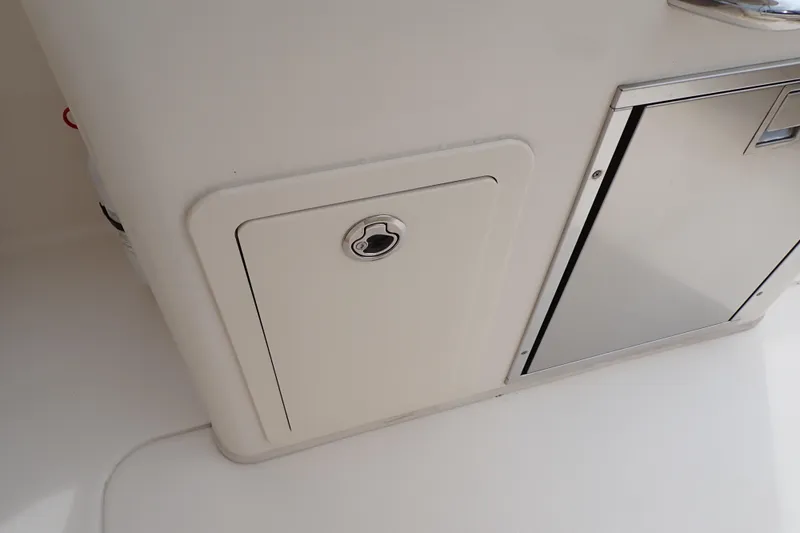 Slide: The Image of 2016 Grady-White Freedom 275 boat storage compartment and stainless steel door. - 28