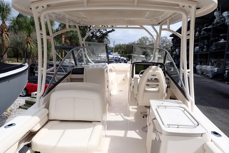 Slide: The Image of 2016 Grady-White Freedom 275 boat interior with seating and helm, surrounded by palm trees. - 3