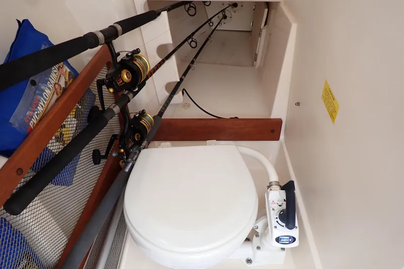 Slide: The Image of 2016 Grady-White Freedom 275 boat interior with fishing rods and marine toilet. - 45