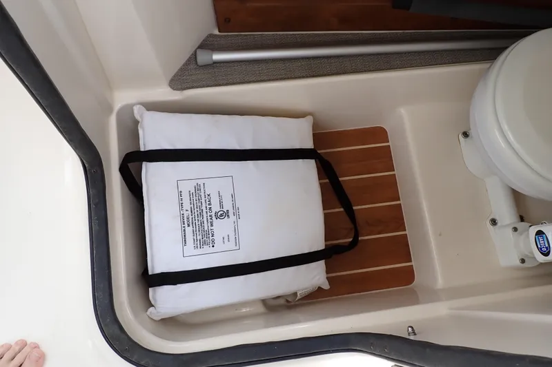 Slide: The Image of 2016 Grady-White Freedom 275 boat interior with life jacket and marine toilet. - 49
