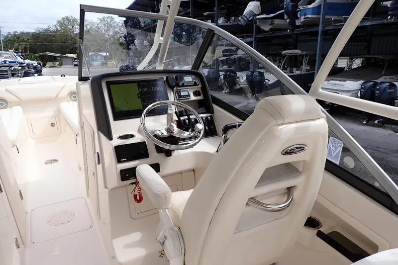 Slide: The Image of 2016 Grady-White Freedom 275 boat cockpit with steering wheel and navigation display. - 5