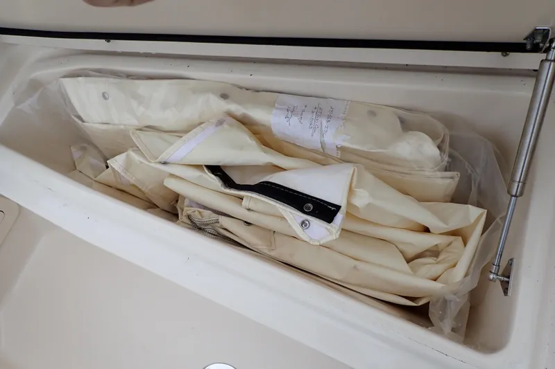 Slide: The Image of Storage compartment with folded canvas on a 2016 Grady-White Freedom 275 boat. - 61