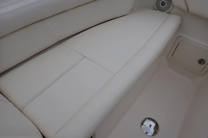 Slide: The Image of 2016 Grady-White Freedom 275 boat interior with white cushioned seating and speaker. - 63