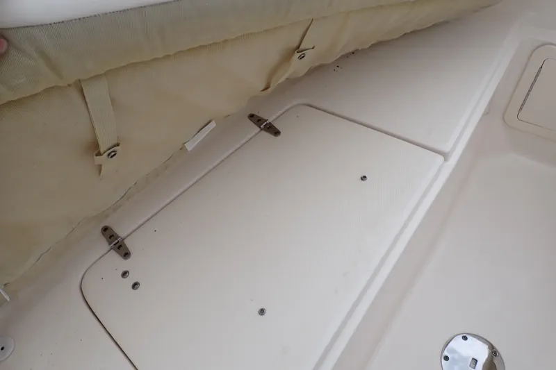 Slide: The Image of 2016 Grady-White Freedom 275 boat storage compartment with beige cover and metal hinges. - 64