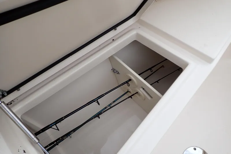 Slide: The Image of 2016 Grady-White Freedom 275 boat rod storage compartment, showcasing organized fishing rods. - 65