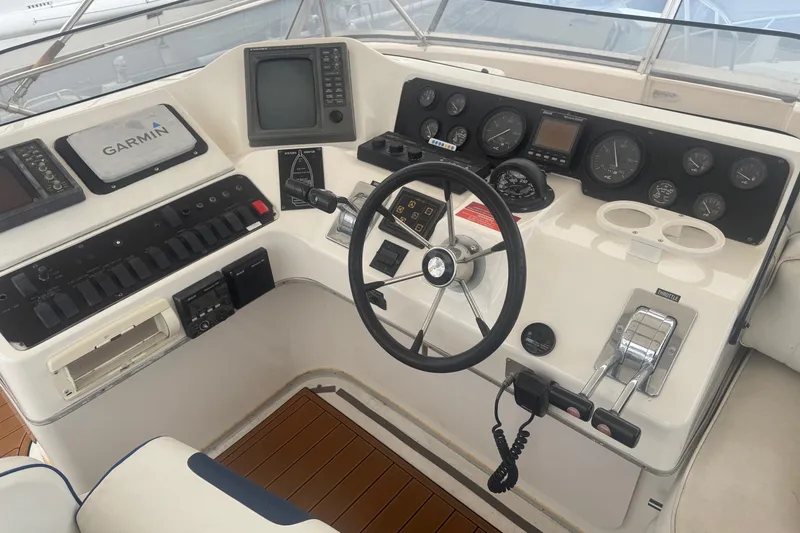 Slide: The Image of 1994 Sea Ray 44 Express Bridge helm with gauges, steering wheel, and controls. - 14