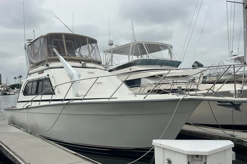 The Image of 1989 Egg Harbor 41 Convertible yacht docked at marina under cloudy skies. - 1