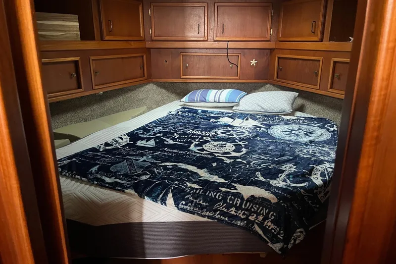 Slide: The Image of Cozy cabin interior of 1989 Egg Harbor 41 Convertible with nautical-themed bedding. - 10