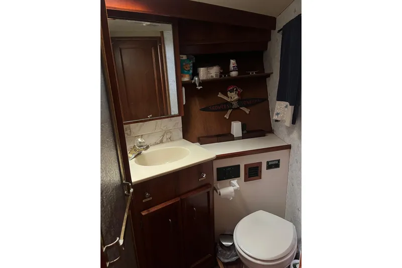 Slide: The Image of 1989 Egg Harbor 41 Convertible yacht bathroom with sink, toilet, and wooden cabinetry. - 12