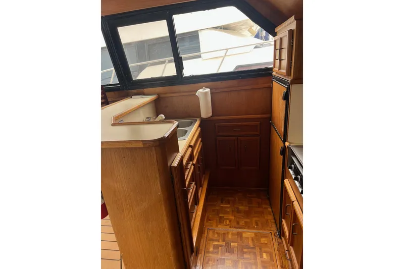 Slide: The Image of 1989 Egg Harbor 41 Convertible yacht kitchen with wooden cabinetry and parquet flooring. - 14