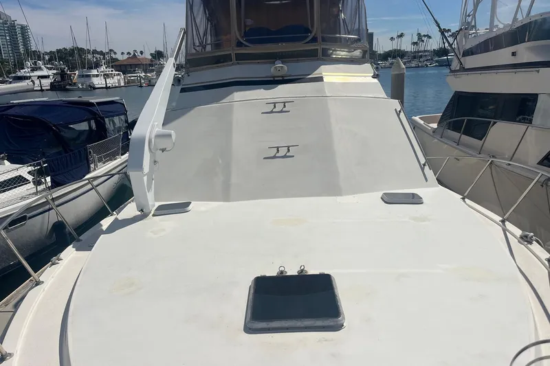 Slide: The Image of 1989 Egg Harbor 41 Convertible yacht docked at marina, showcasing spacious deck. - 27