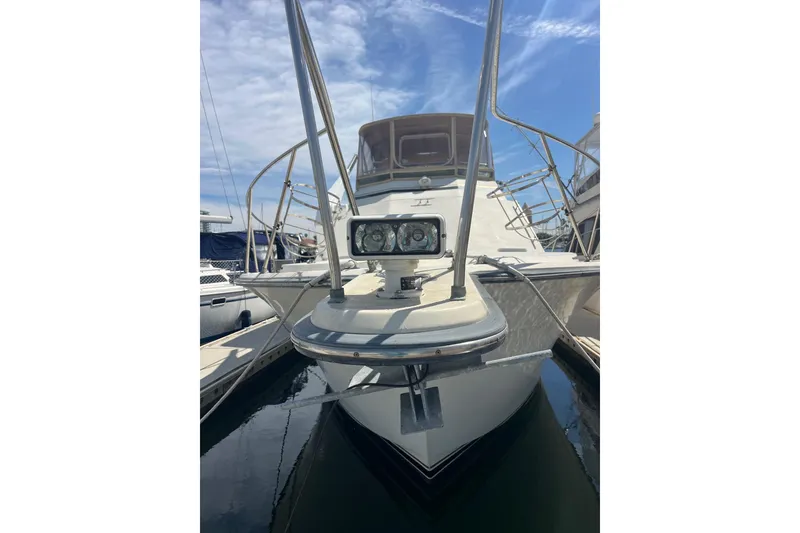 Slide: The Image of 1989 Egg Harbor 41 Convertible yacht docked, front view with clear sky background. - 29