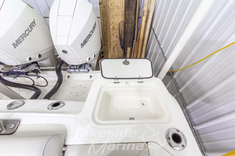 Slide: The Image of 2023 Boston Whaler 250 Outrage boat with dual Mercury engines in a marina setting. - 12