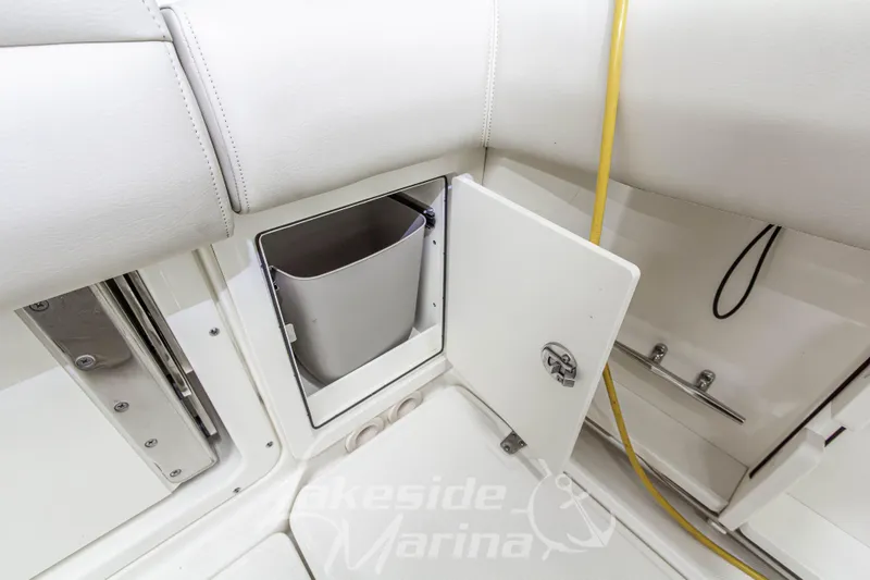Slide: The Image of 2023 Boston Whaler 250 Outrage interior storage compartment with open door and bucket. - 17