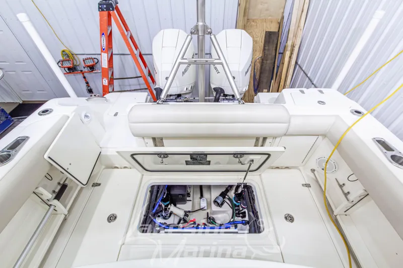 Slide: The Image of 2023 Boston Whaler 250 Outrage boat interior with open storage compartment and Mercury engine. - 21