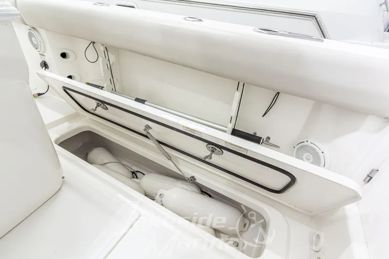 Slide: The Image of 2023 Boston Whaler 250 Outrage boat storage compartment with open hatch and visible fenders. - 24