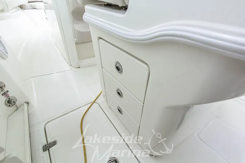 Slide: The Image of 2023 Boston Whaler 250 Outrage interior with storage compartments and sleek white design. - 26