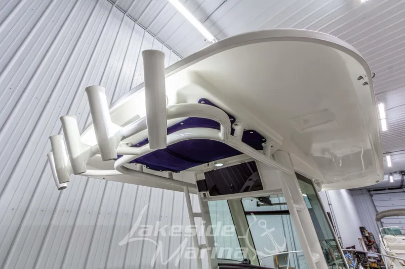 Slide: The Image of 2023 Boston Whaler 250 Outrage boat with rod holders, showcased indoors at Lakeside Marina. - 28