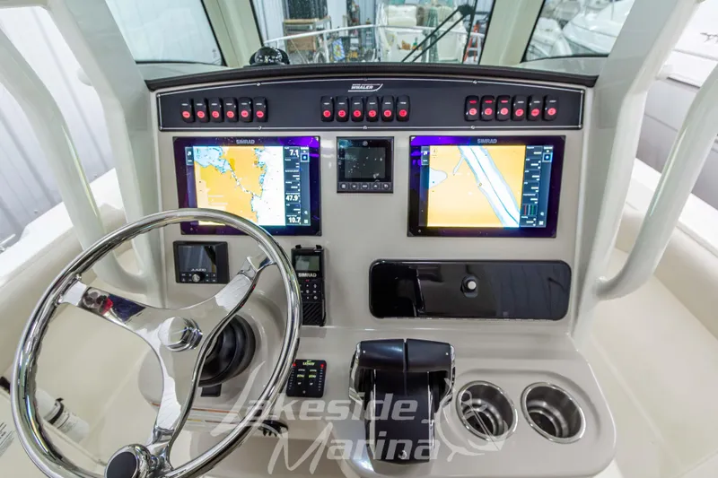 Slide: The Image of 2023 Boston Whaler 250 Outrage dashboard with dual Simrad displays and steering wheel. - 35
